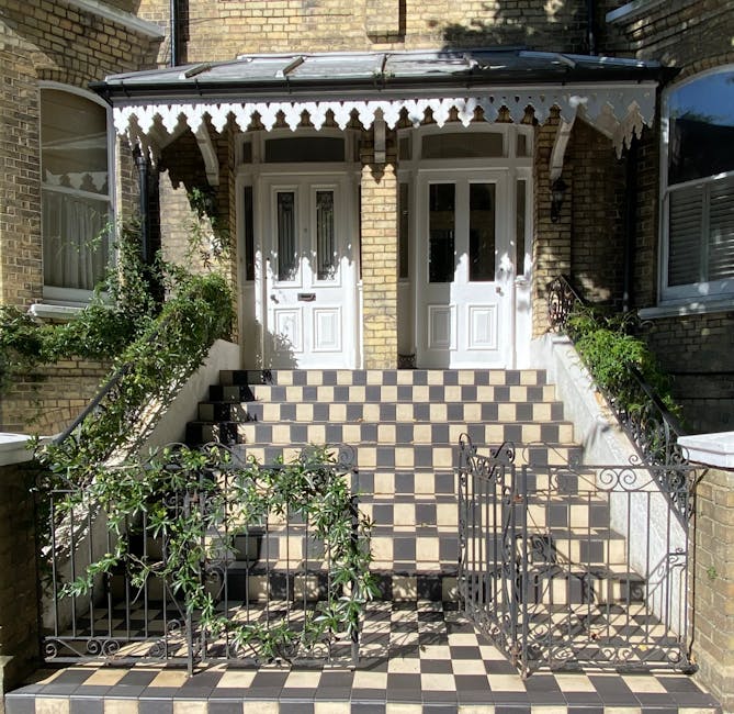 The photograph features the front entrance of a stately traditional house, showcasing a symmetrical facade with a pale mauve front door framed by classical white columns and decorative moulding. The d